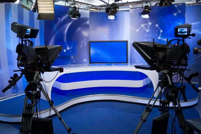 shutterstock_94783030-3 A television studio setup with cameras and a blue backdrop