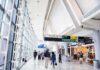 Airport Rebrand Sparks Eight-Figure Shock Airport terminal hallway with travelers and signage
