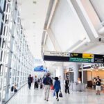 Airport Rebrand Sparks Eight-Figure Shock Airport terminal hallway with travelers and signage