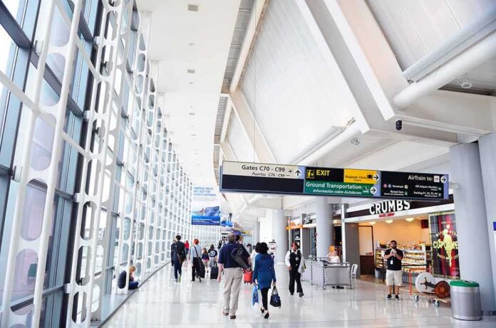 shutterstock_99344561 Airport terminal hallway with travelers and signage