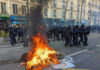Marseille Inferno: Woman Torched Amid Riots Fire burning on the street amid police presence.