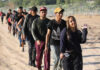 Migrant Caravan Heads North From Tapachula Line of people walking along a dirt path outdoors