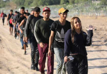 Migrant Caravan Heads North From Tapachula Line of people walking along a dirt path outdoors