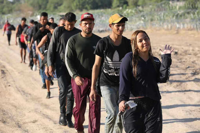Line of people walking along a dirt path outdoors