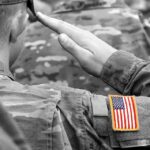 Soldier saluting with an American flag patch on sleeve