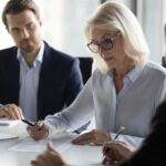 Businesswoman signing a document at a meeting table