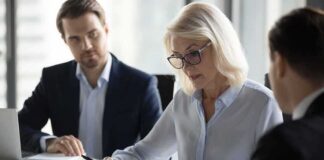 Businesswoman signing a document at a meeting table