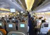 A Cockpit Attack Tests Aviation Security Interior view of an airplane with passengers seated and using in-flight entertainment screens