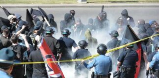 David Givens among police and protesters in a smoky street confrontation