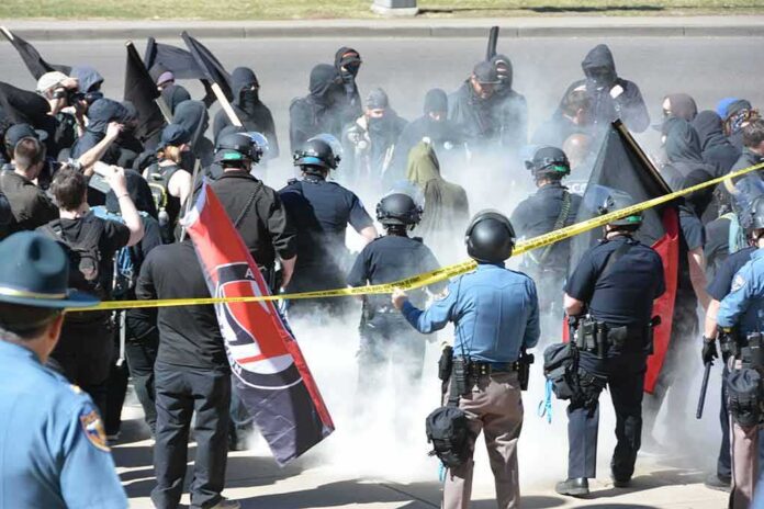 shutterstock_1472772608 David Givens among police and protesters in a smoky street confrontation
