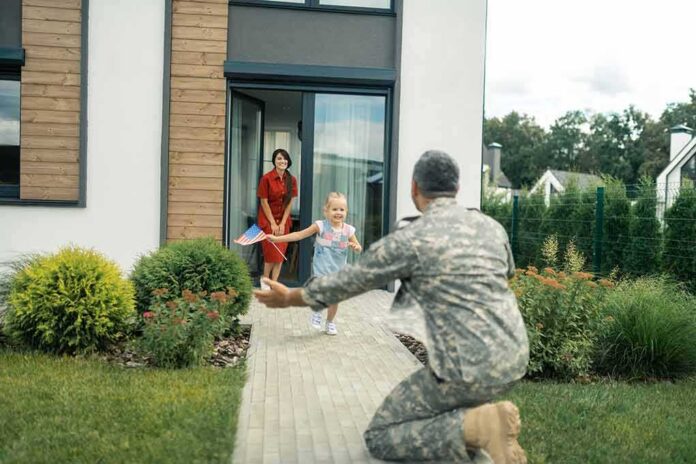 shutterstock_1476496232-1 soldier kneeling to embrace daughter on home walkway