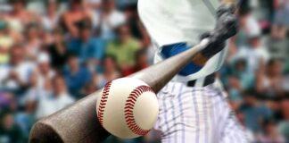Baseball player hitting a ball with a wooden bat