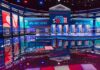 One Word, Two Political Standards at CNN? Televised debate stage with multiple podiums and bright red, white, and blue lighting