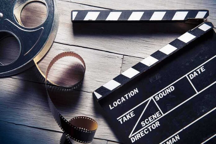 shutterstock_169841813 Film reel and clapperboard on wooden surface