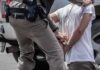 Hammer Attack Stuns ICE Stop police officer handcuffing a person beside a vehicle