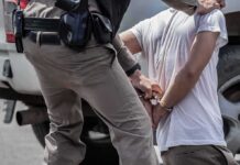 Hammer Attack Stuns ICE Stop police officer handcuffing a person beside a vehicle