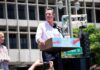 Gavin Newsom speaking at an outdoor rally podium