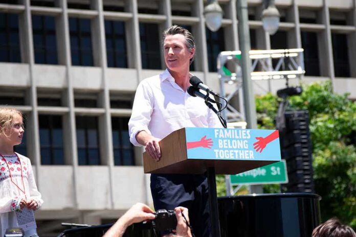 shutterstock_1747777526-1 Gavin Newsom speaking at an outdoor rally podium