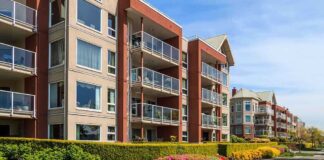 Modern apartment buildings with balconies and landscaped gardens on a sunny day