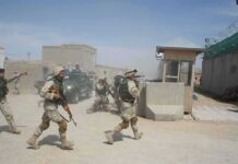 Foreign Aid Poured In – Insurgents Grew Anyway Soldiers in desert uniforms run past a checkpoint amid dust