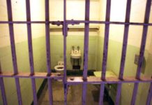 Governor Showdown Looms Over Manson Follower Interior of a prison cell with a toilet, sink, and metal bars