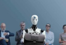 Jan-Peter Nikiferow seated with a humanoid robot holding a briefcase in front