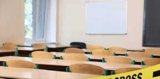 Empty classroom with police tape across desks