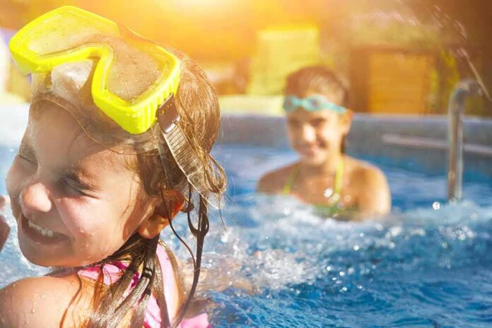 shutterstock_429203542 children playing in a swimming pool with goggles
