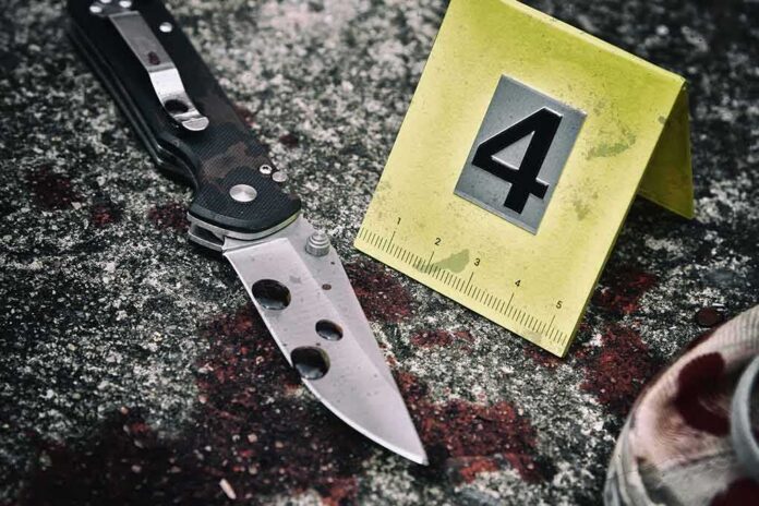 shutterstock_678374095 Folding knife beside evidence marker on gritty surface