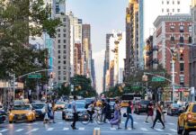 One-Year-Old Killed After Crosswalk Crash Busy city street with pedestrians crossing and yellow taxis
