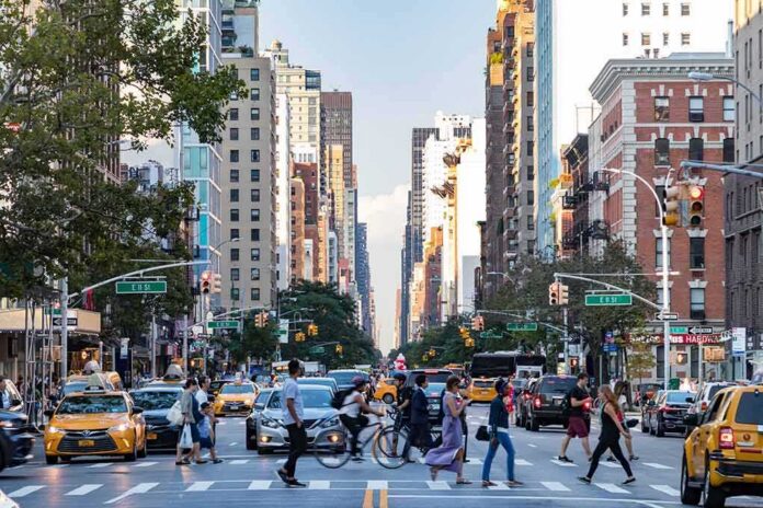 Busy city street with pedestrians crossing and yellow taxis